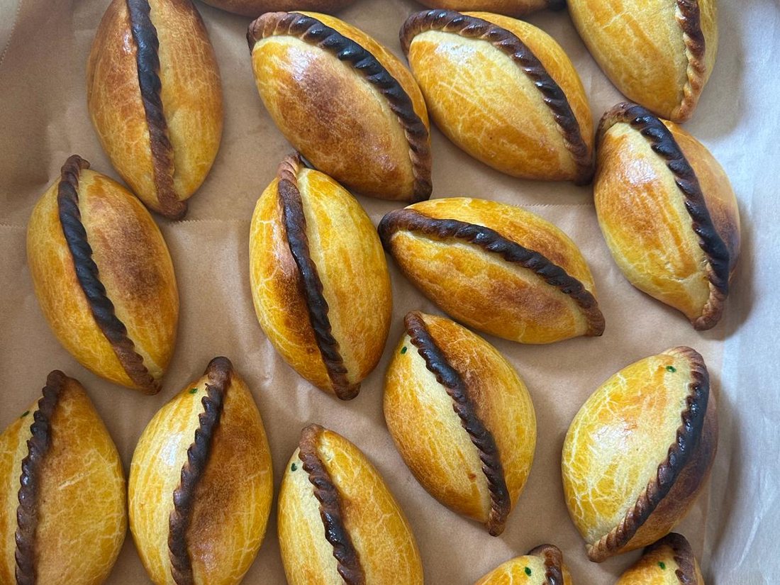 A tray of baked salteñas